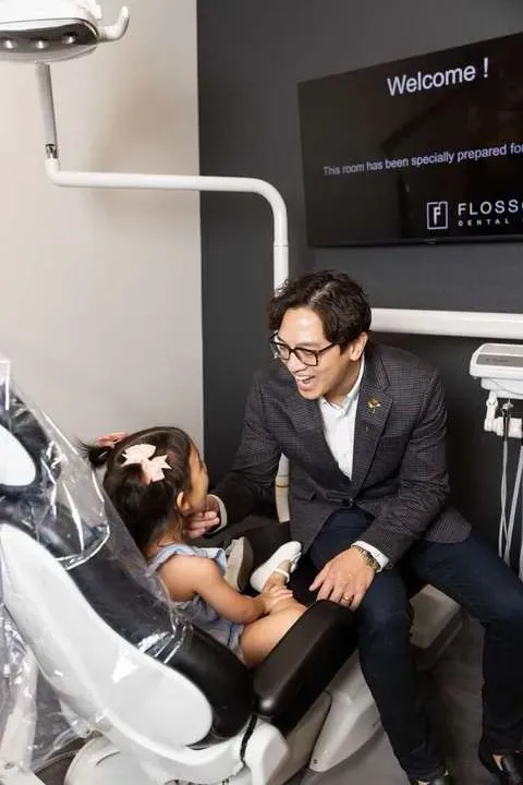 Dr. Matthew Le with a young patient at Flossophy Dental Studio